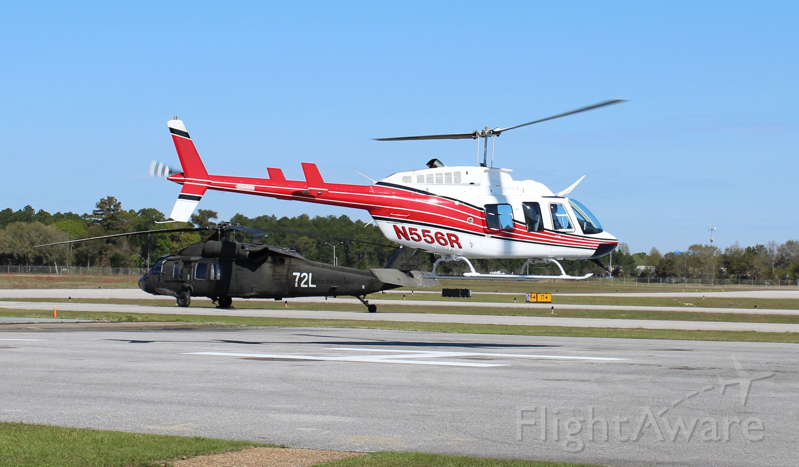 N556R — - A Bell 206 LongRanger IV departing the Gulf Air Center ramp with a Blackhawk in the background at Jack Edwards National Airport, Gulf Shores, AL - March 16, 2017. 