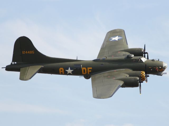 — — - The mighty Memphis Belle, B-17 Flying Fortress, performs a flypast at Duxford Air Museum.