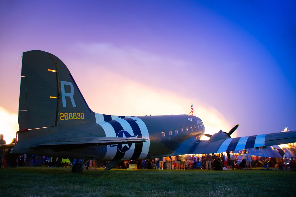 Douglas DC-3 (N45366) - C-47 "D-Day Doll" at the EAA Airventure 2019 Wednesday Night Show with the Shockwave Jet Truck lighting up the background.