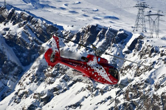 Eurocopter EC-130 (HB-ZAZ) - Air Zermatt - Eurocopter EC-130 T2. Behind is a small part of the Matterhorn Ski Paradise.br /I took this picture on the Gornergrat (3090 meters above sea level / 10138 ft).br /Photo taken on January 6, 2022 at 10°F.br /br /You find two other pictures of this flight here:br /br /https://flightaware.com/photos/view/6098442-c6bb1b10e899ddb30a0edc4b44a1c85867418307/aircraft/HBZAZ/sort/votes/page/1br /https://flightaware.com/photos/view/6098442-24983bb711061f8894681c75ce9d3ca570f00b05/aircraft/HBZAZ/sort/votes/page/1