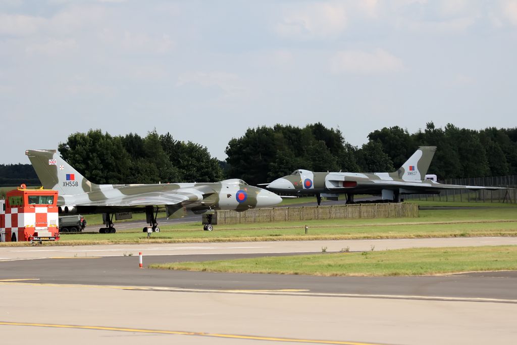 — — - A then (still) flyable Vulcan taxis in next to another preserved Vulcan at RAF Waddington, UK
