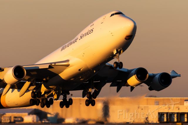 Boeing 747-400 (N577UP) - UPS 744 rotating off of 17R in the very last rays of sun. 