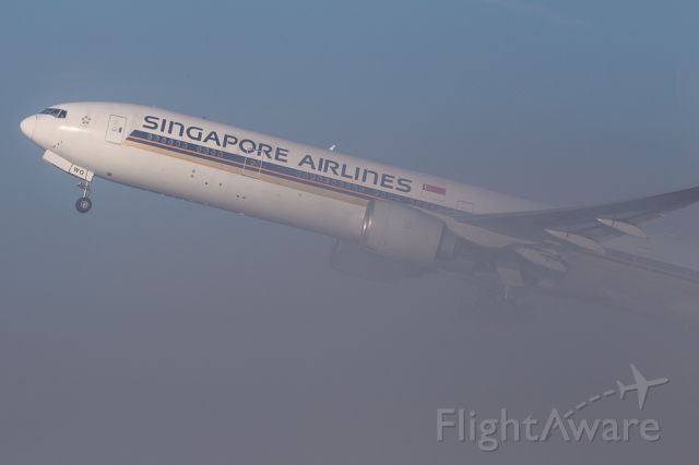 BOEING 777-300ER (9V-SWG) - SIA52 emerging from the fog at Manchester on departure to IAH