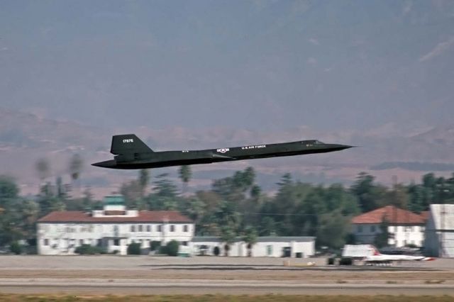 Lockheed Blackbird (61-7975) - Lockheed SR-71A 61-7975 makes a low altitude pass as it departs March AFB on November 3, 1980, the day after an airshow. The Thunderbirds T-38A Talons are parked on the flightline.