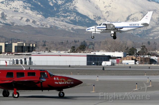 Piper Navajo (N59973) - A Piper Aerostar (N888KT, The Spirit of Kai Tak) waits at the Charlie taxiway hold point as an Ameriflight Piper covers the final few feet of its approach to Reno Tahoe Internationals runway 16L.