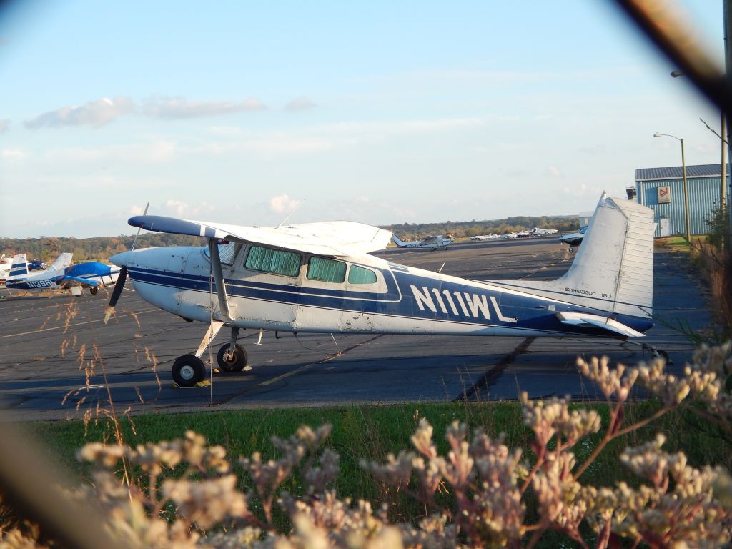 Cessna Skywagon 180 (N111WL) - Airplanes At Manassas Airport. N111WL, a 1973 Cessna Skywagon 180, N1396W, a 1964 Mooney M-20, and N6382S, a 1980 Cessna Turbo Skylane RG, sit on the ramp at Manassas Reginal Airport in 2020.