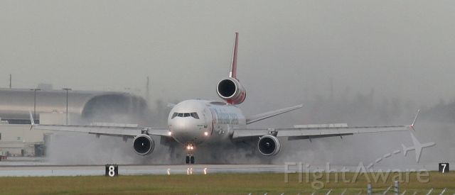 Boeing MD-11 (PH-MCW) - Martinair MD-11 landing with full reversers and spoilers on a wet runway 27 at KMIA