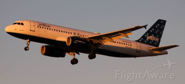 Airbus A320 (N584JB) - On Final 30L, With sunset reflecting off of jet