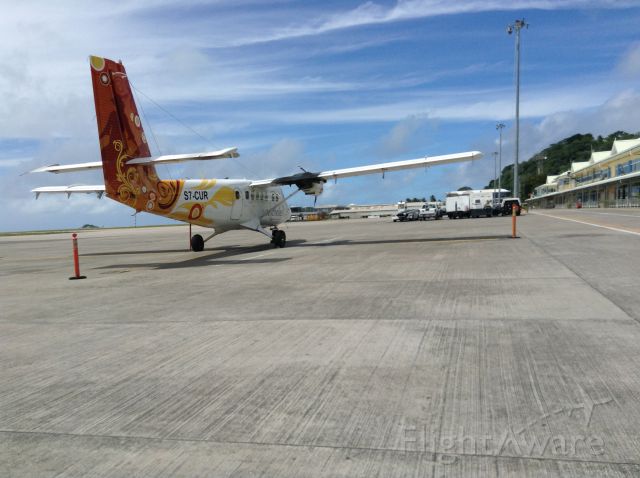 — — - A DH 6 in her bright livery sits ready for 15 minute flight to Praslin island from Pointe Larue International Airport in Seychelles.