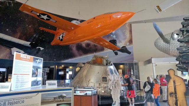 — — - A mock-up of the Bell X-1 at the San Diego Air and Space Museum. Below the X-1 is the actual command module from the Apollo 9 mission. It orbited the Earth in March, 1969.