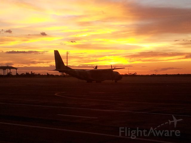 — — - Pôr do sol na Base Aérea de Campo Grande com um avião C-105 Amazonas ao fundo.