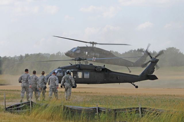 Sikorsky S-70 (8226378) - Air Force troops prepare to board US Army National Guard UH-60A Blackhawk 82-23678 as simulated patients with an Army Medic as Blackhawk 90-26307 lands in the background at Fort McCoy/Young Air Assault Strip (WS20) on 17 Jul 2013.