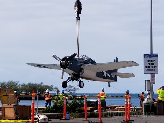 N5833 — - A F4F (FM-2 Wildcat) gets a free flight onto a barge before being loaded onto the USS Essex for a ride from O'ahu to the Mainland.