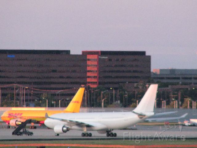 — — - An unidentified white aircraft with NO tail registration number sits just adjacent from a DHL Cargo Aircraft at ORD