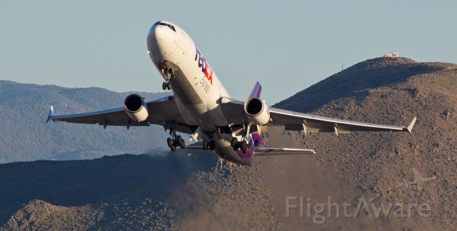 Boeing MD-11 (N597FE) - The Snake (Rattlesnake Mountain) makes a neat background to this capture when "Corbin," a Fed Ex MD-11 (N597FE), is caught at sunset with throttles at max power and just beginning to put the wheels in the wells as it powers up and away from runway 34L at Reno during its 7:32 PM departure for an evening trip east to Memphis.